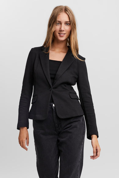 Blazer noir par VERO MODA, porté sur un débardeur noir et un jean noir délavé.