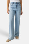 Jean large denim bleu clair de OPUS, porté avec un débardeur blanc et des mocassins beiges.