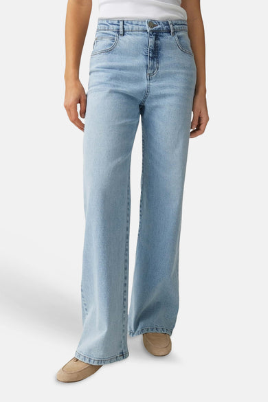Jean large denim bleu clair de OPUS, porté avec un débardeur blanc et des mocassins beiges.