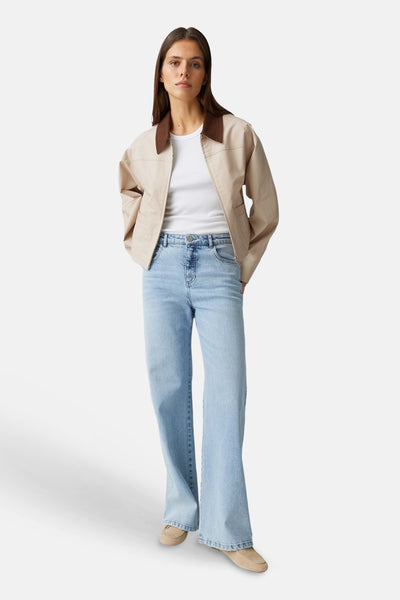 Jean large en denim bleu clair de OPUS, porté par une femme avec un t-shirt blanc et une veste beige.