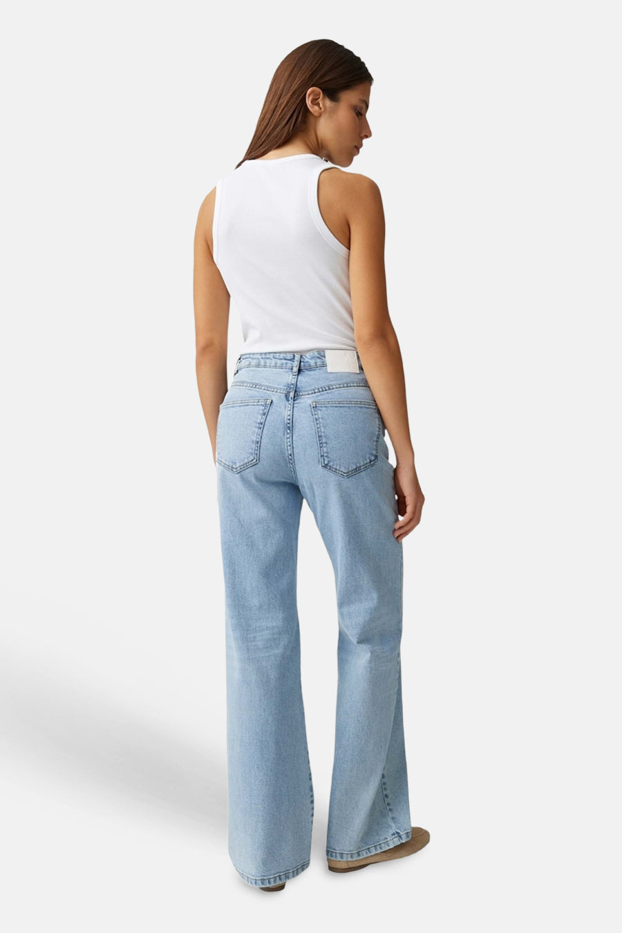 Jean large en denim bleu clair de OPUS, vue de dos, porté avec un débardeur blanc et des chaussures marron.