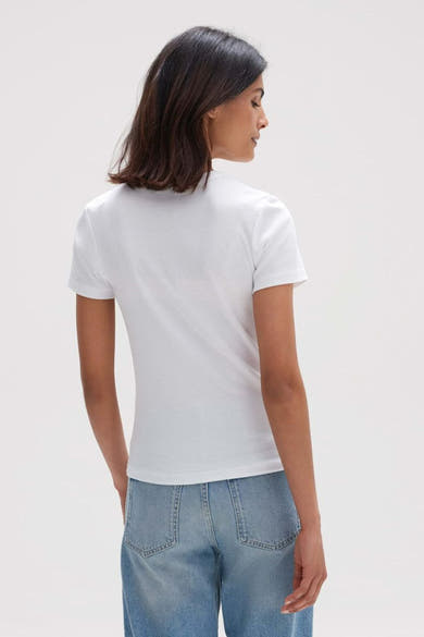 Blouse blanche à manches courtes de OPUS, avec texture côtelée, portée avec un jean bleu, vue de dos.