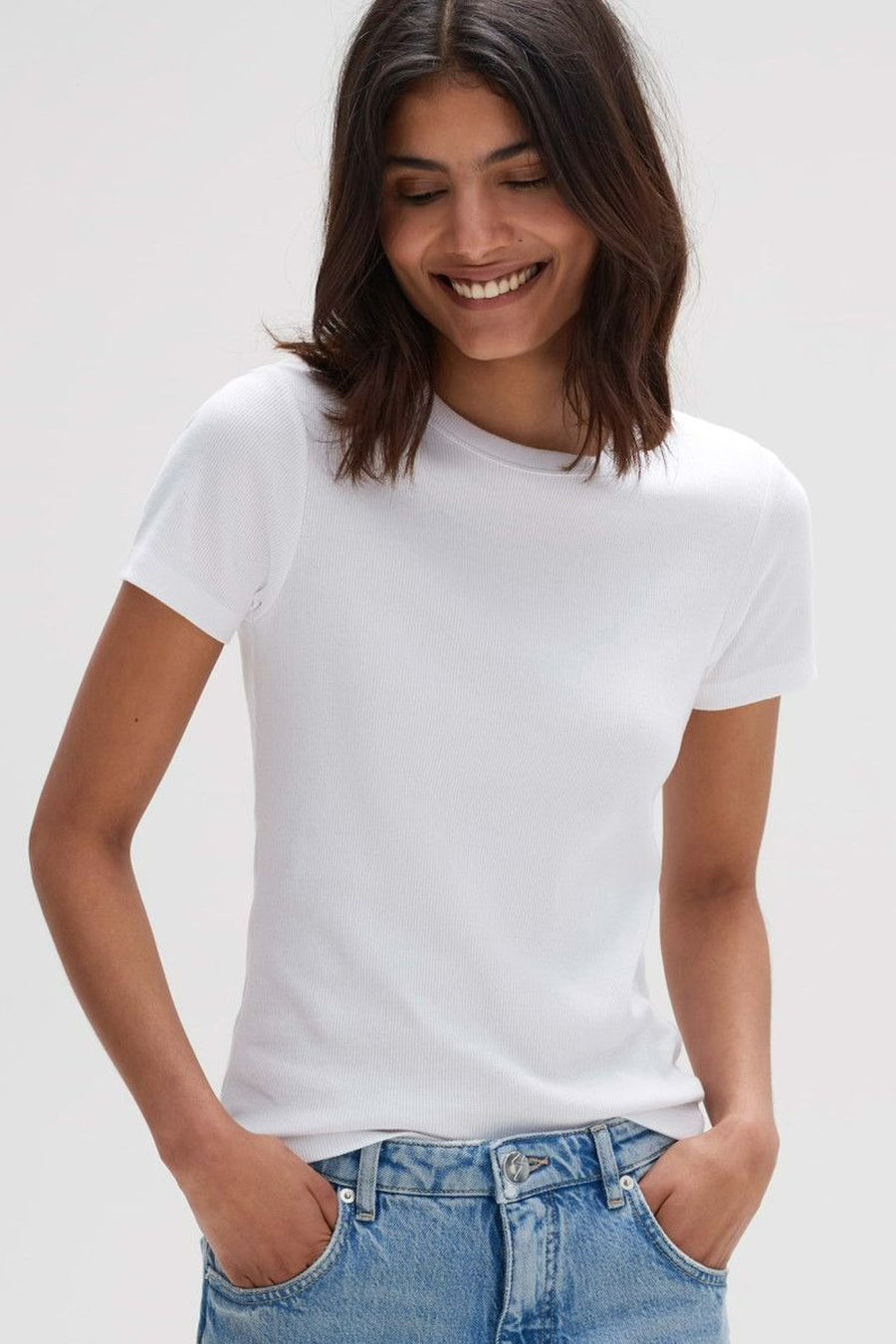 Blouse blanche à manches courtes van OPUS, en maille côtelée, portée avec un jean bleu clair.