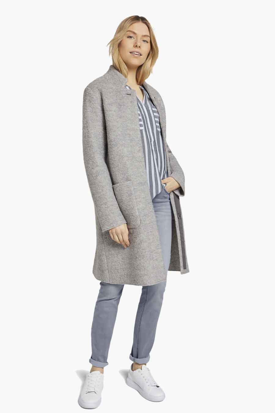 Chemisier bleu à manches longues de Tom Tailor, porté avec un manteau gris et un jean bleu.