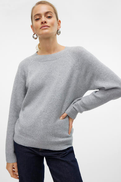 Pull gris col rond de VERO MODA, porté avec un jean bleu marine et des boucles d'oreilles argentées.