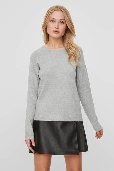 Pull gris de VERO MODA, porté avec une jupe courte en similicuir noir.