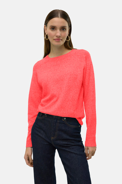 Pull ras du cou orange par VERO MODA®, porté avec un jean bleu foncé et des boucles d'oreilles dorées.