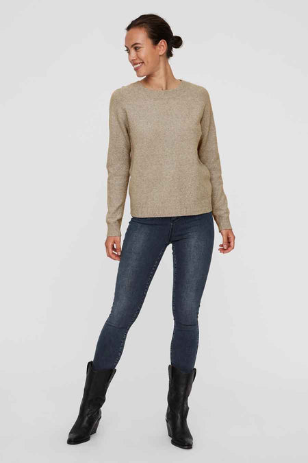 Pull beige de VERO MODA, porté avec un jean foncé et des bottes en cuir noires.