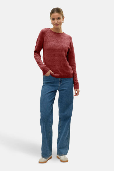 Pull rouge à col rond de Vero Moda, porté avec un jean bleu et des chaussures décontractées.