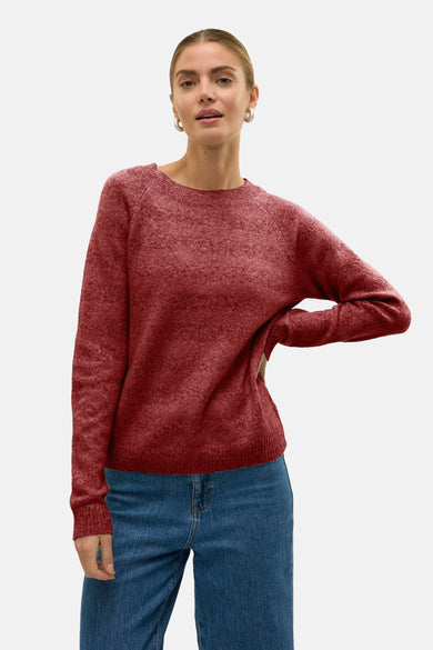 Pull à col rond rouge de VERO MODA, porté avec un jean taille haute et des boucles d'oreilles argentées.
