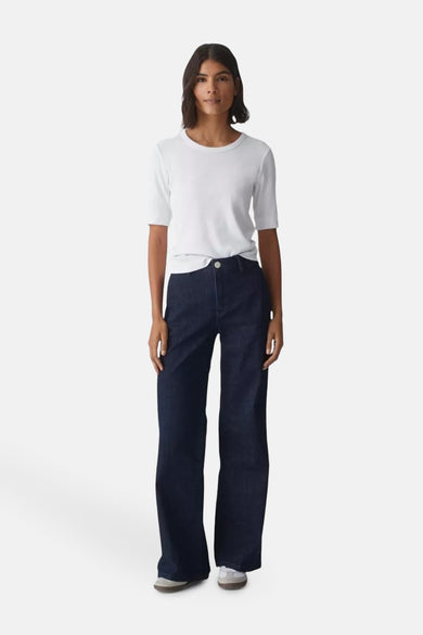 T-shirt blanc à manches courtes par OPUS, porté avec un jean large bleu foncé.
