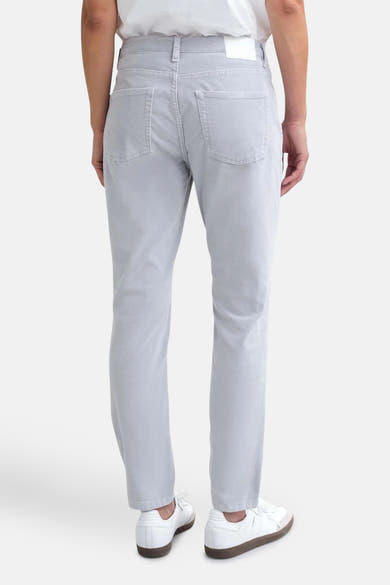 Jean femme décontracté de OPUS, gris clair, avec poches arrière et chaussures blanches.