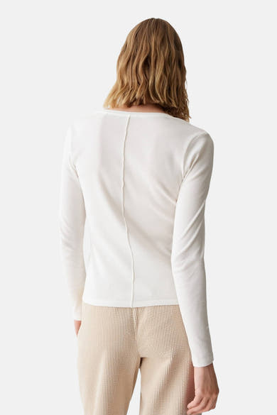 Dos d’un pull blanc à col rond OPUS, porté avec un pantalon beige.