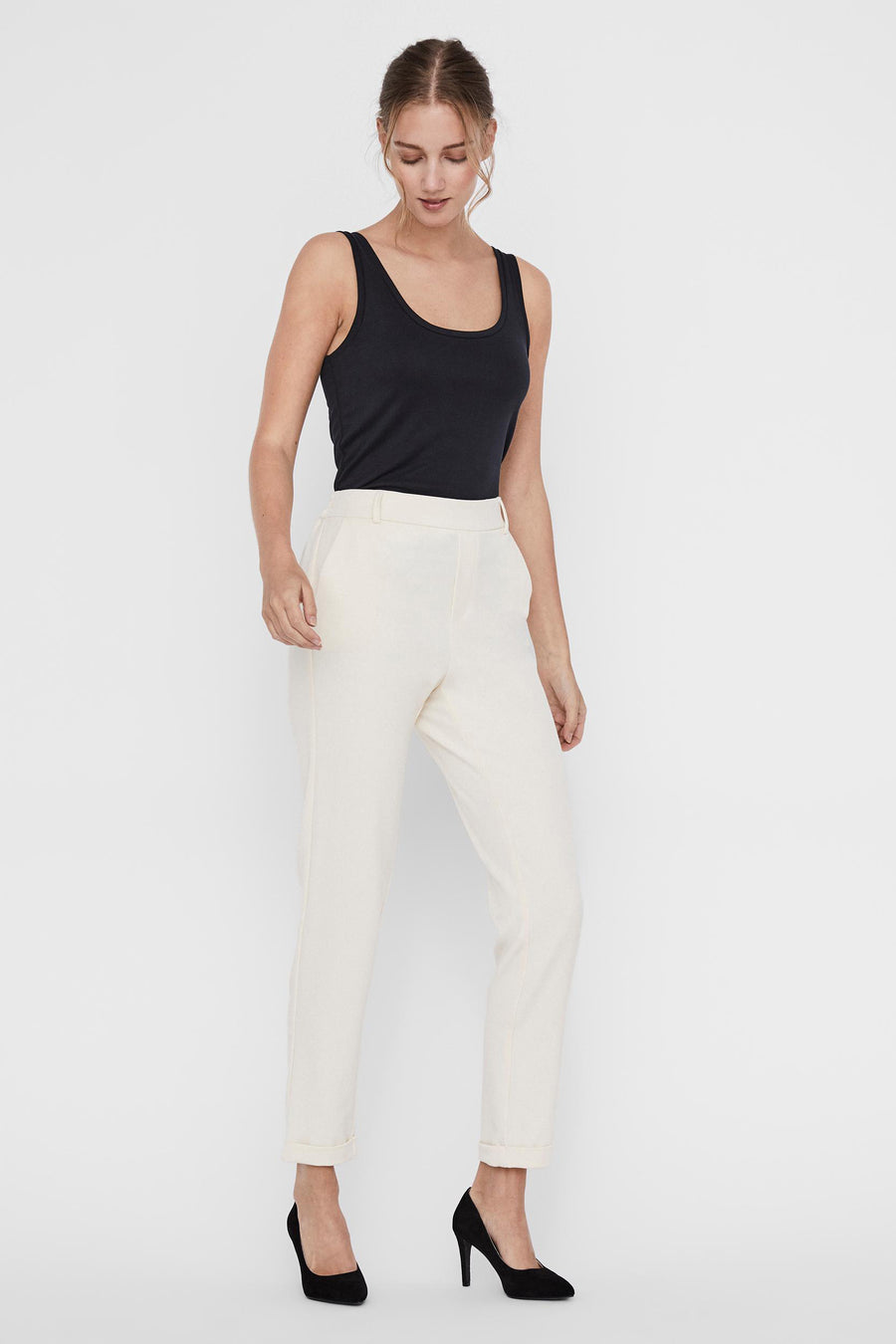 Pantalon de costume beige de Vero Moda, porté avec un débardeur noir et des escarpins noirs.