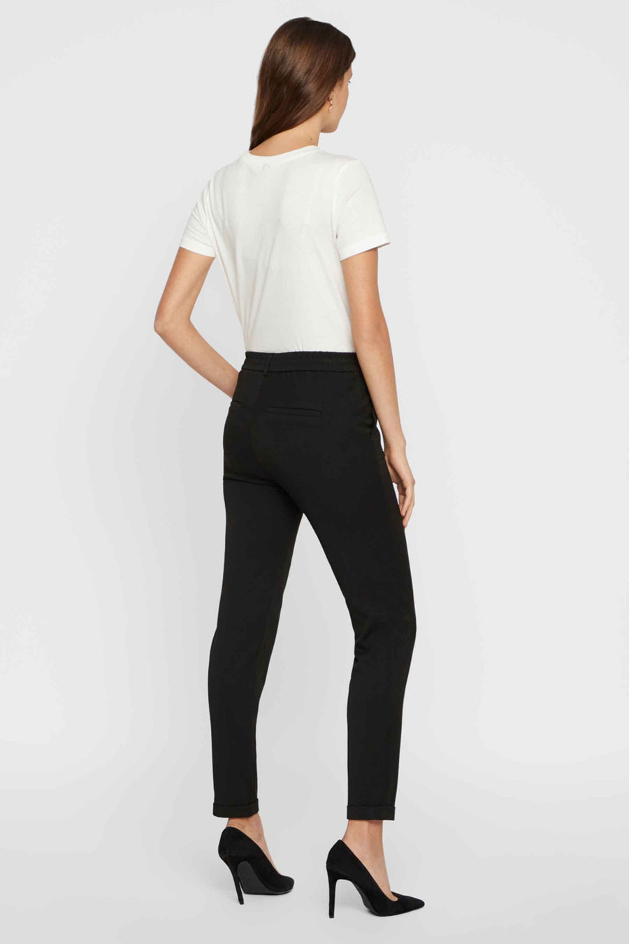 Pantalon de costume noir de Vero Moda, porté avec un t-shirt blanc et des escarpins noirs.