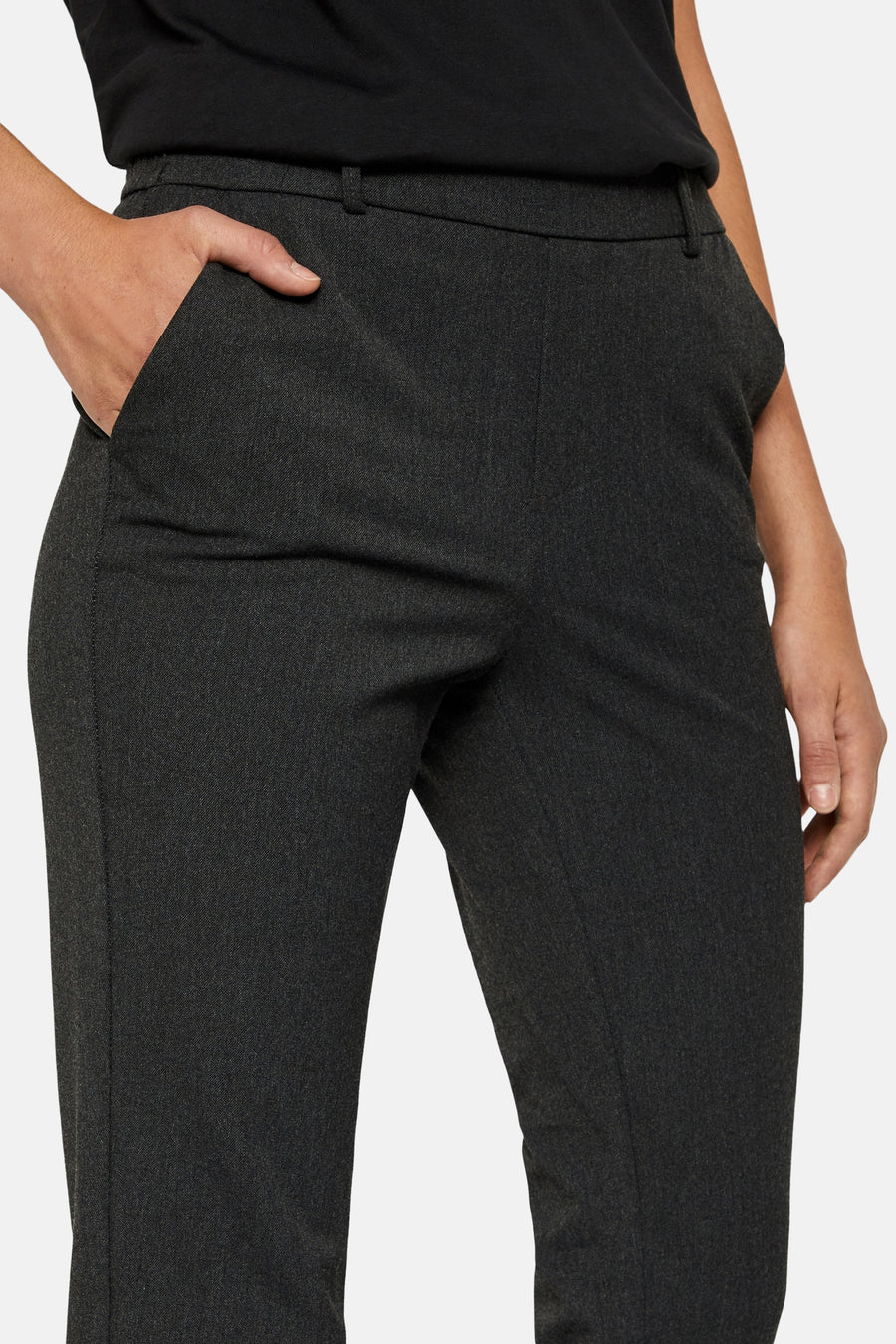 Pantalon de costume gris par Vero Moda, avec une main dans la poche, porté avec un t-shirt noir.