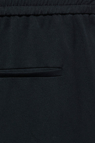 Pantalon de costume bleu de VERO MODA, avec une texture en tissu subtile et une poche latérale discrète.