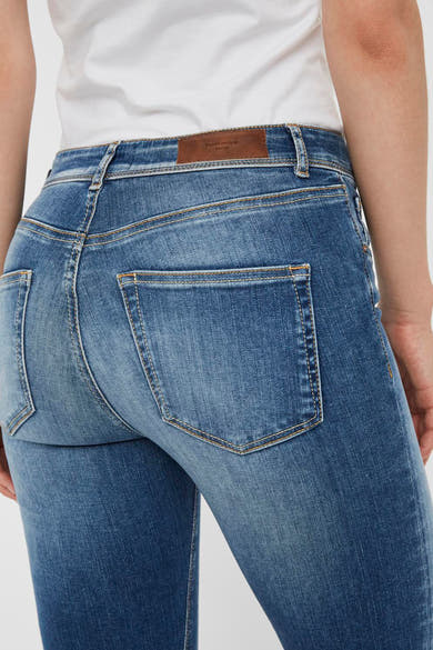 Jean skinny bleu moyen de VERO MODA, avec poches arrière, détail de surpiqûres et empiècement en cuir à la taille.