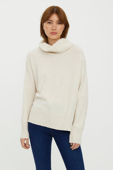 Pull col montant beige de VERO MODA, porté avec un jean bleu foncé.