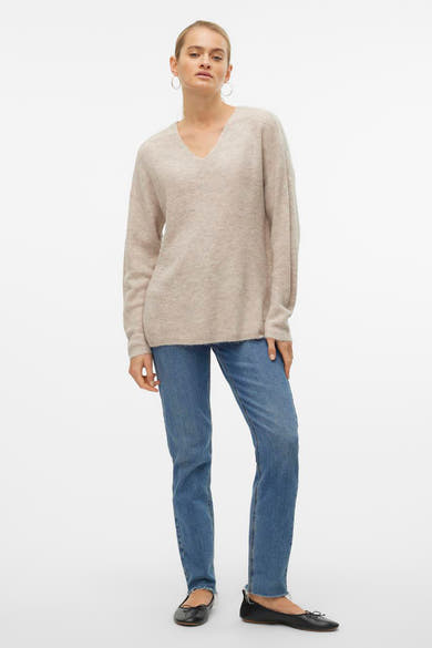 Pull col V écru de VERO MODA, porté avec un jean bleu et des ballerines noires.