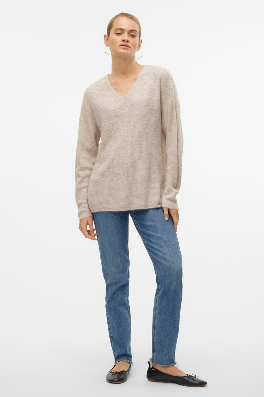 Pull col V écru de VERO MODA, porté avec un jean bleu et des ballerines noires.