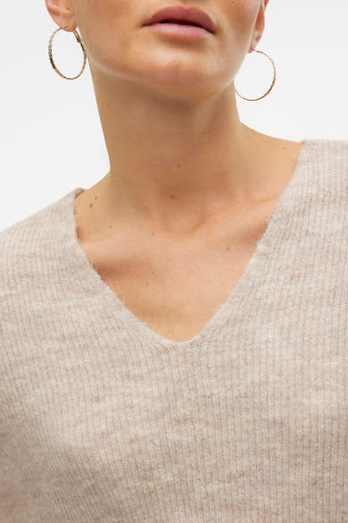 V-hals trui in ecrukleurige gebreide stof van VERO MODA, met gouden oorbellen.