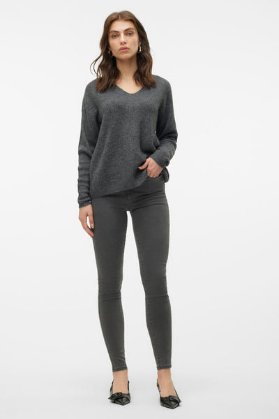 Grijze V-hals trui van Vero Moda, gedragen met een grijze skinny jeans en zwarte pumps.