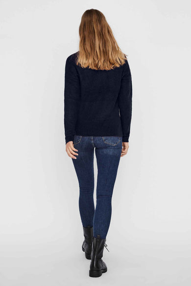 Pull à col en V bleu par VERO MODA, porté avec un jean et des bottes, vue de dos.
