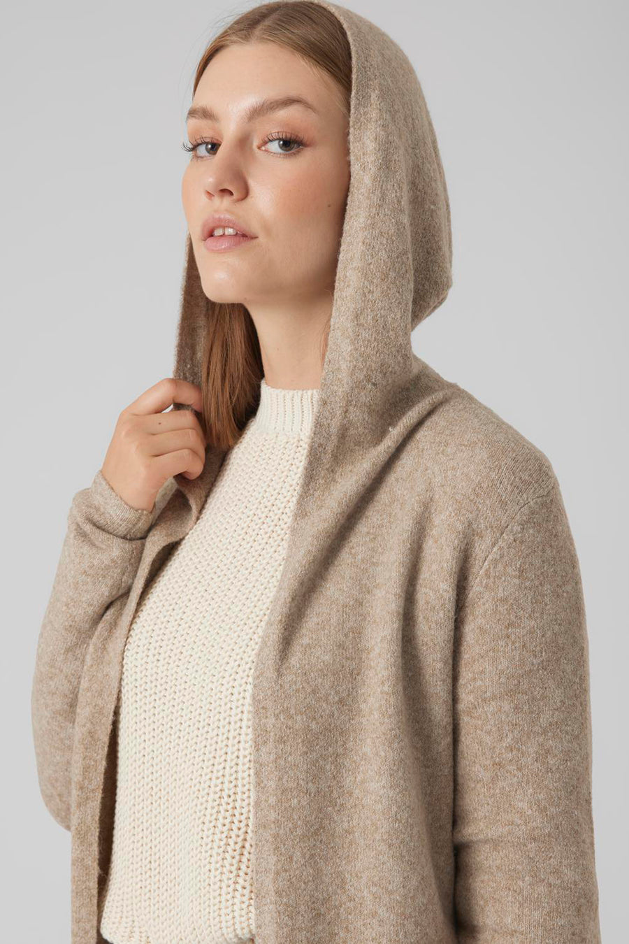 Beige capuchonvest van VERO MODA, gedragen over een witte trui, zachte textuur.