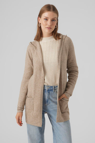 Cardigan beige de VERO MODA à capuche, avec poches plaquées, porté sur un pull crème et un jean bleu.

