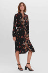Multicolored floral print robe with black base, wrap front, long sleeves, and side slit, worn with strappy heels, front view