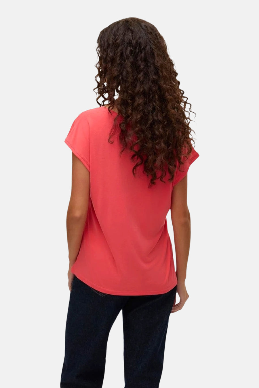 T-shirt rose à manches courtes de Vero Moda, porté avec un jean foncé, vue de dos, avec des cheveux bouclés.
