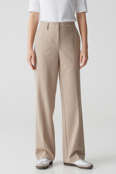 Beige broek van OPUS, wijde pasvorm, gedragen met een wit T-shirt en witte sneakers.