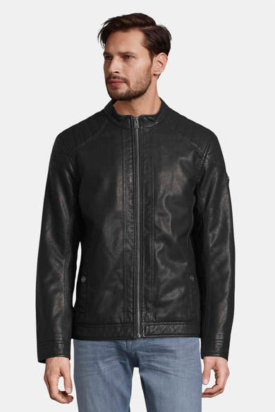 Veste en simili cuir noire de Tom Tailor avec fermeture éclair et poches latérales, portée avec un jean bleu.