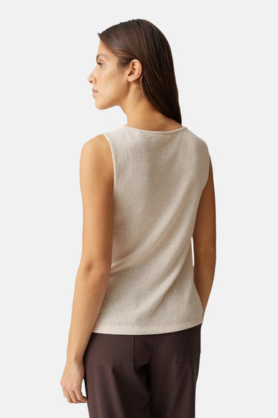 Top sans manches beige par OPUS, en texture tricotée fine, porté avec un pantalon marron uni.
