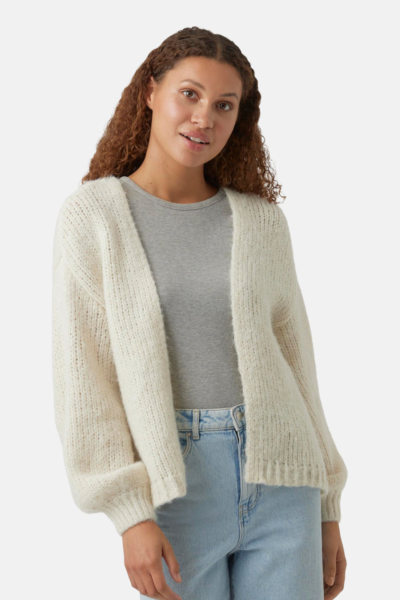 Beige cardigan van VERO MODA, in dikke gebreide stof, gedragen over een grijs T-shirt en een high-waisted jeans.