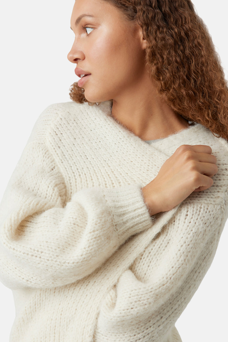 Beige vest van VERO MODA®, in dik breiwerk gedragen door een vrouw, zijwaarts gezien.