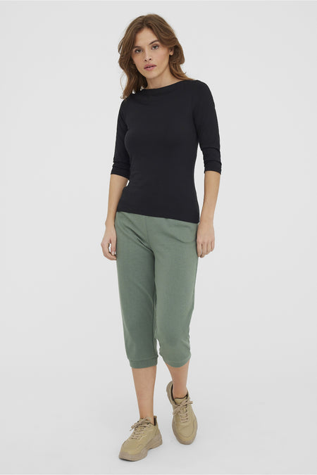 Effa gekleurd zwart T-shirt met lange mouwen van VERO MODA, gedragen met een olijfgroene capri en beige sneakers.