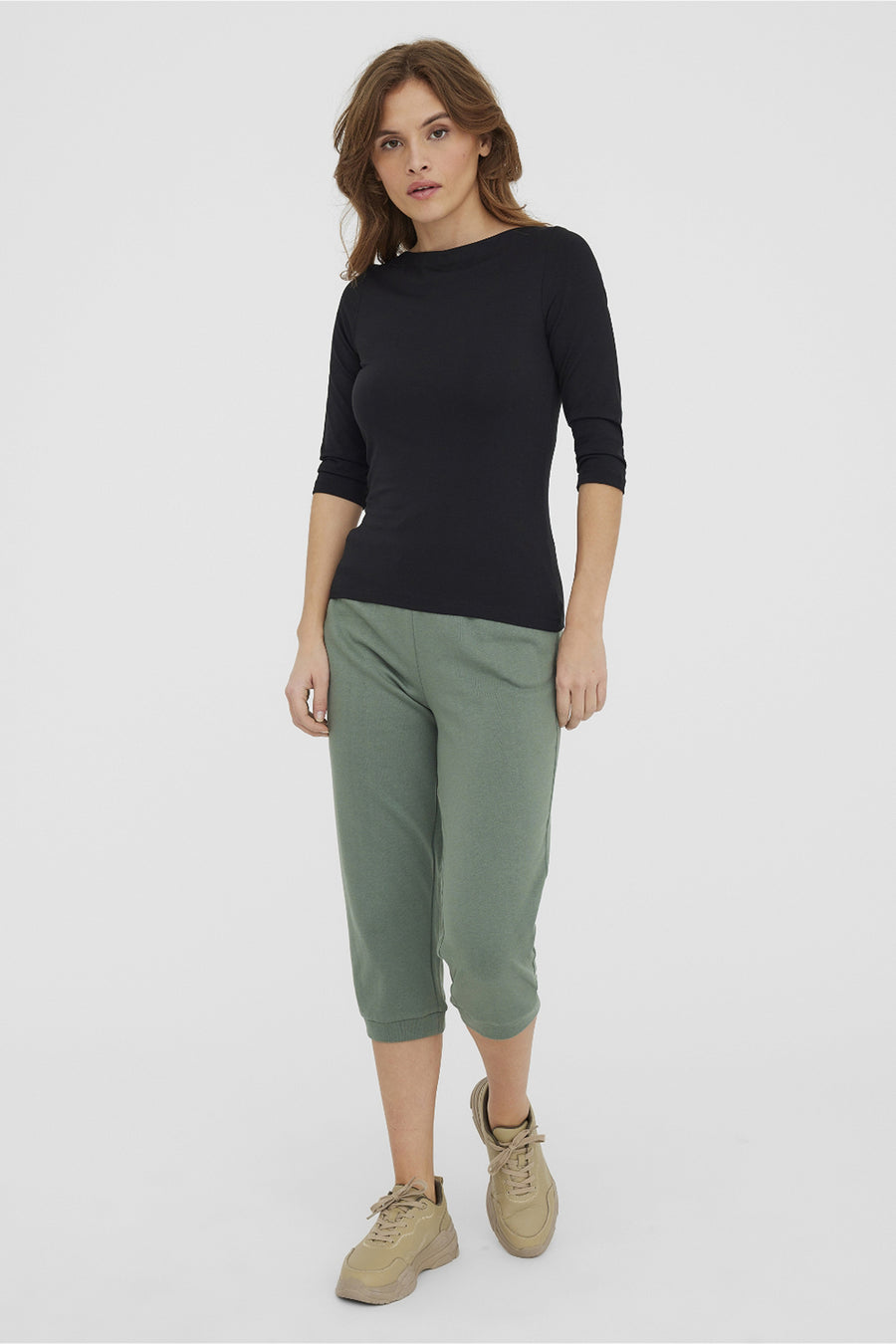 Effa gekleurd zwart T-shirt met lange mouwen van VERO MODA, gedragen met een olijfgroene capri en beige sneakers.