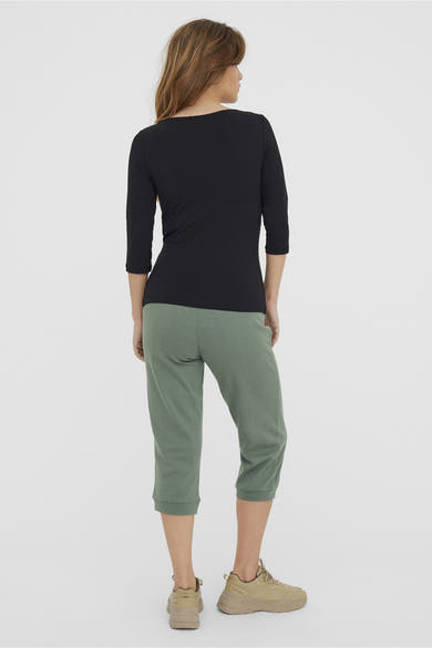 Effenchemise zwart T-shirt met driekwartmouwen van Vero Moda, gedragen met saliegroene capri en zandkleurige sneakers.