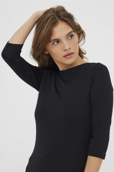 Zwarte top met lange mouwen van VERO MODA®, gedragen met los haar.