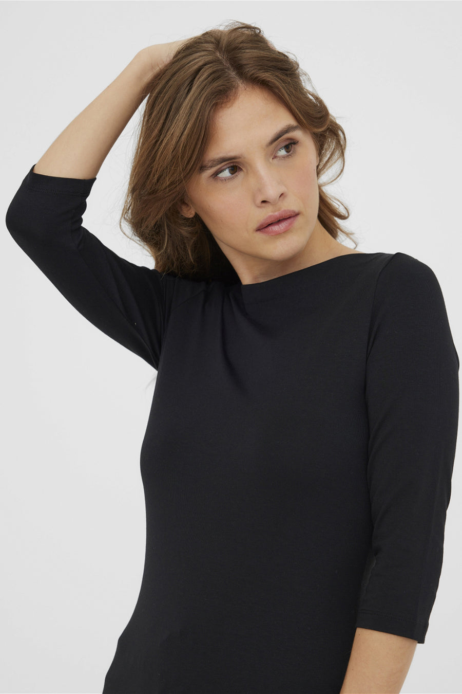 Zwarte top met lange mouwen van VERO MODA®, gedragen met los haar.