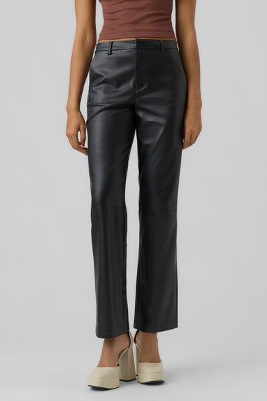 Pantalon noir en similicuir de Vero Moda, porté avec un top marron et des chaussures compensées ivoire.