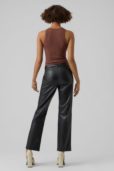 Pantalon noir en similicuir de Vero Moda, porté avec un débardeur marron et des chaussures à talons compensés.