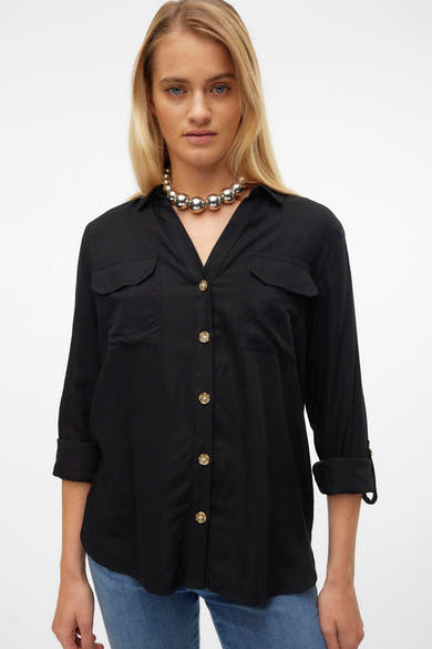 Chemise à manches longues noire de VERO MODA, avec poches poitrine et collier à grosses billes argentées.
