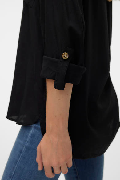 Chemise noire à manches longues de Vero Moda, avec manches retroussées et bouton en bois.