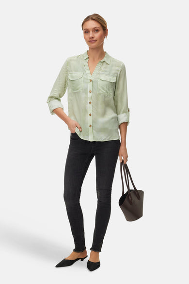 Chemise à manches longues verte à rayures blanches de VERO MODA®, portée avec un jean noir et des mules.