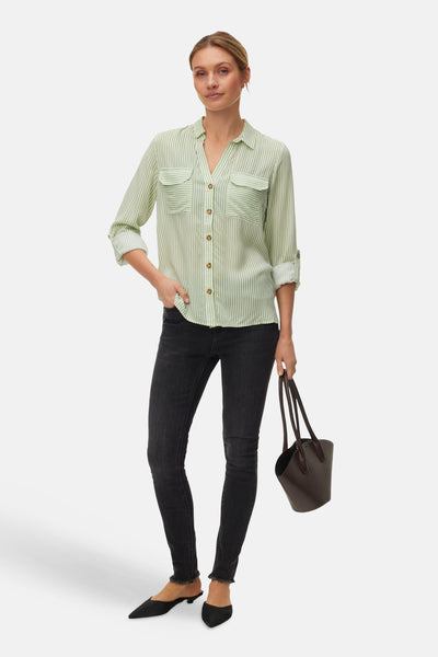 Chemise à manches longues verte à rayures blanches de VERO MODA®, portée avec un jean noir et des mules.