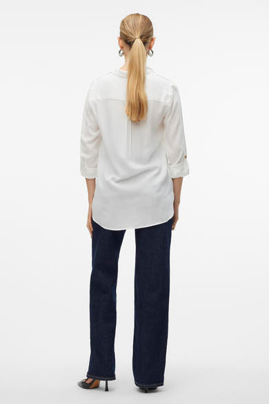 Chemise à manches longues blanche de Vero Moda, portée avec un jean et des chaussures à talons, vue de dos.