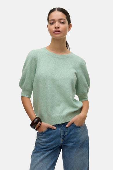 Groene trui met ronde hals van Vero Moda, gedragen met een wijde blauwe jeans en zwarte loafers.